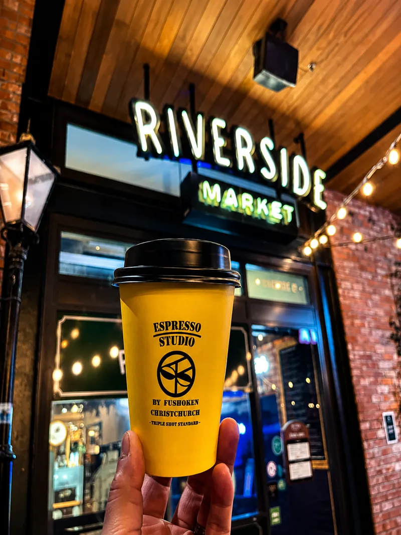 Yellow Espresso Studio cup held outside Riverside Market